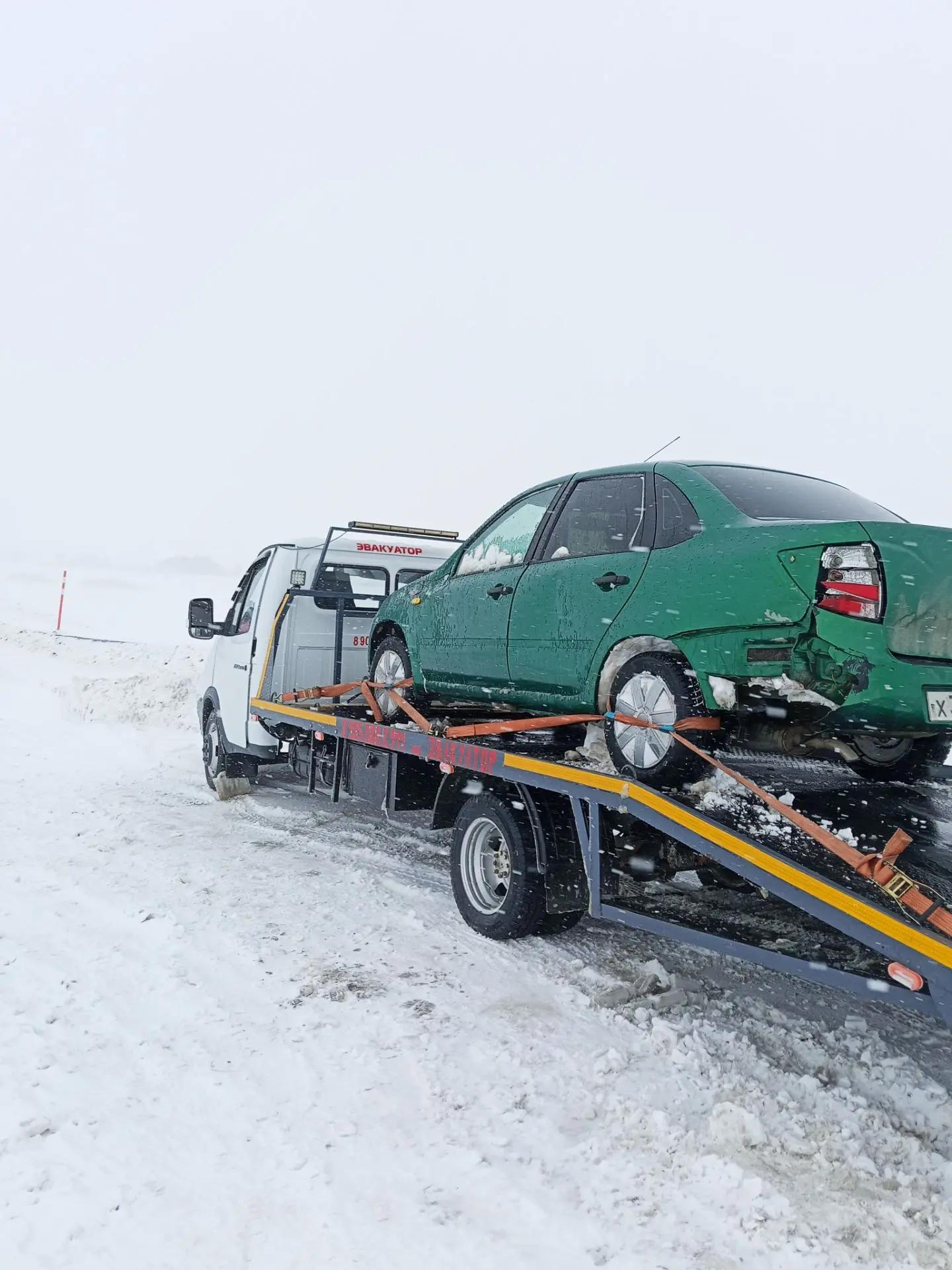 Эвакуатор из Орска везёт автомобиль по трассе на закате