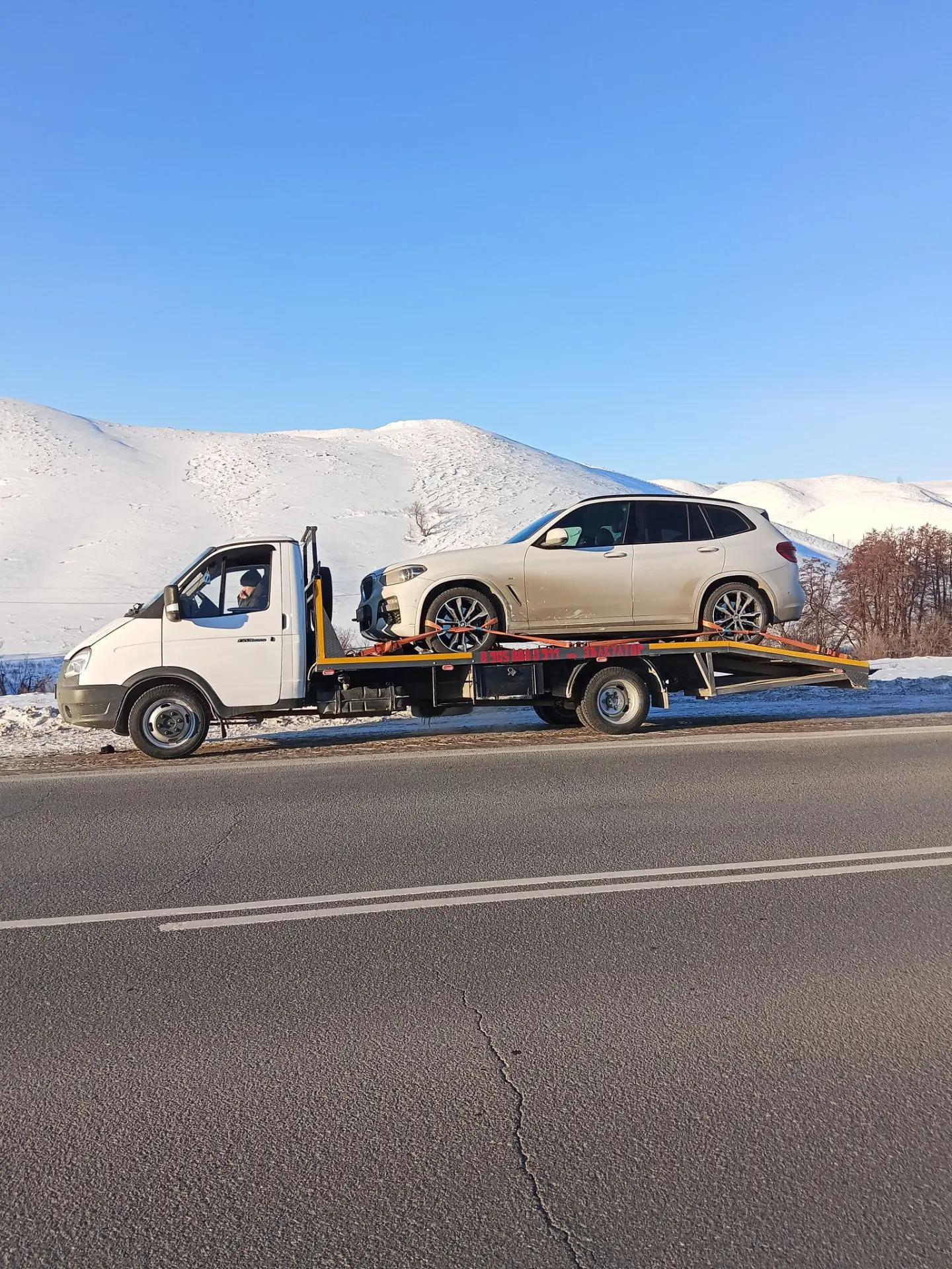 Эвакуатор из Орска везёт автомобиль по трассе, межгород по всей России